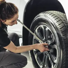 Mecánica trabajando en el cambio de ruedas de un coche.