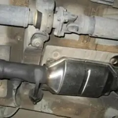Sistema de escape de Renault con posible fallo DTC P0420. Se observa hollín en el tubo de conexión al catalizador.