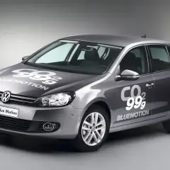 Golf gris con logo "99g CO2 BLUEMOTION" en capó y puerta, mostrando su eficiencia.