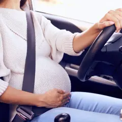 Mujer embarazada al volante con cinturón de seguridad. Un cinturón embarazada homologado DGT es esencial para su seguridad.