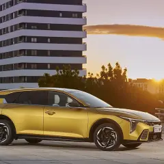 Coche dorado moderno aparcado frente a un edificio al atardecer. ¿Buscas cómo bajar el CO2 de un coche de gasolina?