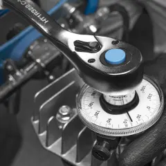 Mano con guante ajusta una llave dinamométrica con dial, mostrando cómo funciona una llave dinamométrica para aplicar el par correcto.