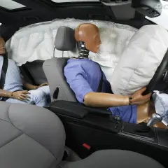 Maniquíes en un coche con airbags desplegados. Muestra cómo funciona un cinturón de seguridad en un impacto.