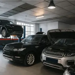 Taller mecánico con varios Range Rover Velar, uno en elevador y otros con capós abiertos, listos para solucionar problemas.