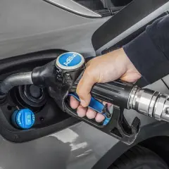 Persona rellena el depósito de AdBlue de un coche. Saber cuanto AdBlue consume un coche es clave para planificar repostajes.
