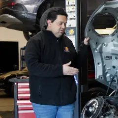 Mecánico experto en **mecánica coches eléctricos** revisa el motor de un Mini Cooper en un taller.
