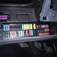 Panel de fusibles de un Seat Ibiza 6J con varios fusibles de colores y un conector púrpura.