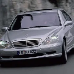 Mercedes plateado en movimiento, con el conductor visible. El sistema Airmatic parece funcionar perfectamente.