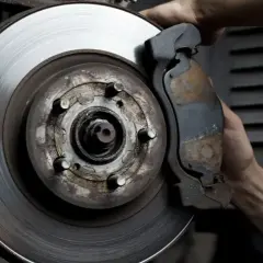 Mano ajustando la pinza de freno a un disco con rebaba.