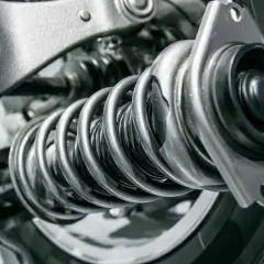 Detalle de un amortiguador y muelle de coche. ¿Cuánto cuesta cambiar los amortiguadores del coche?