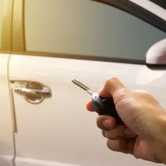Mano sujetando llave para resetear cierre centralizado del coche.