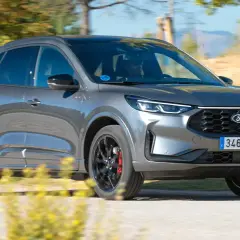 Ford Kuga PHEV en movimiento, con detalles de sus llantas negras y pinzas rojas. A pesar de su aspecto, algunos usuarios reportan ford kuga phev problemas.