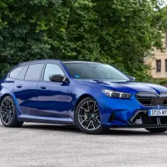 Un BMW azul brillante, un coche familiar con un diseño deportivo, parece un active guard listo para la acción.