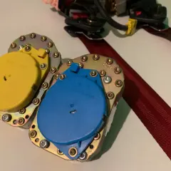Mecanismo de cinturón de seguridad con carretes amarillo y azul, listo para reparar cinturón de seguridad deshilachado.