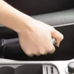 Mano tensando el freno de mano de un Volvo XC90.