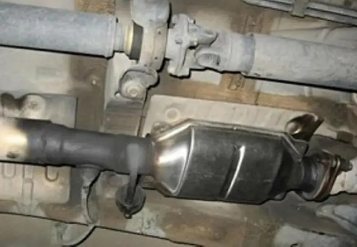Sistema de escape de Renault con posible fallo DTC P0420. Se observa hollín en el tubo de conexión al catalizador.