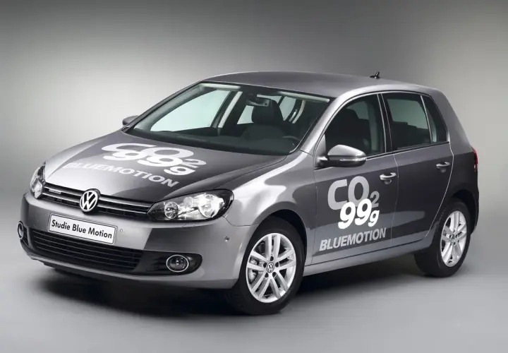 Golf gris con logo "99g CO2 BLUEMOTION" en capó y puerta, mostrando su eficiencia.