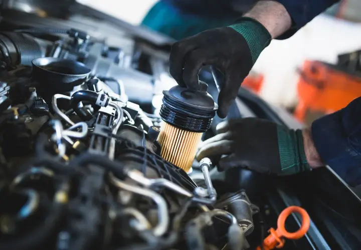 Mecánico reemplaza el filtro de combustible, una pieza esencial para el buen funcionamiento del motor.