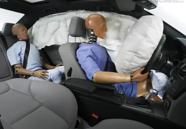 Maniquíes en un coche con airbags desplegados. Muestra cómo funciona un cinturón de seguridad en un impacto.