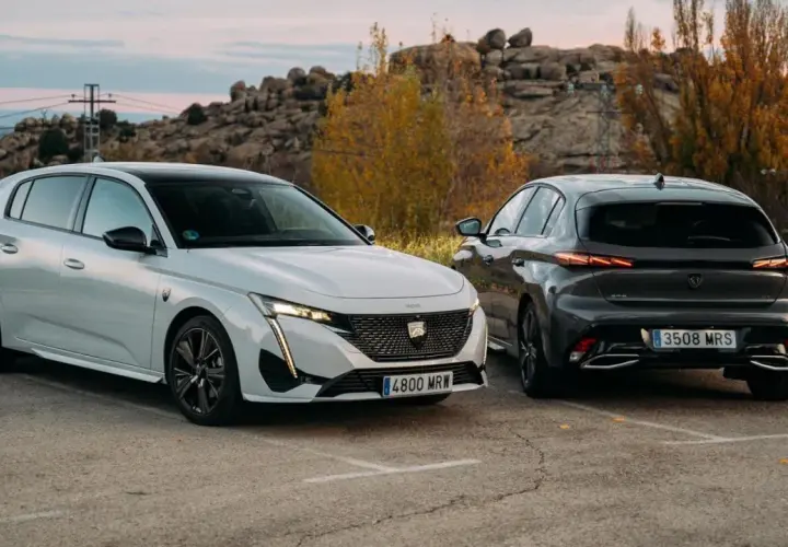 Dos Peugeot 308, uno blanco y otro gris oscuro, aparcados al aire libre. Los coches híbridos son diésel o gasolina, ofreciendo opciones eficientes.