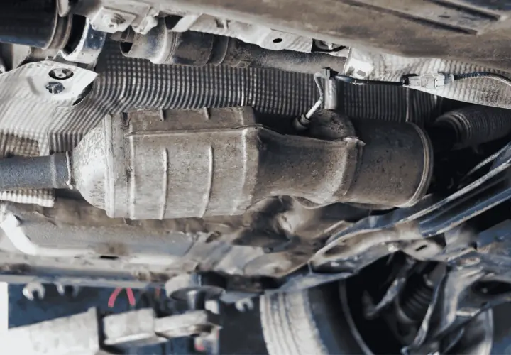 Vista inferior de un coche, mostrando el sistema de escape y el cableado. Se puede apreciar la ubicación del sensor de presión de combustible 1.6 HDI.