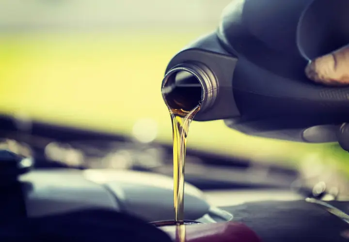 Vertiendo aceite de coche nuevo, ya que el aceite de coche caduca y necesita ser reemplazado para el buen funcionamiento del motor.