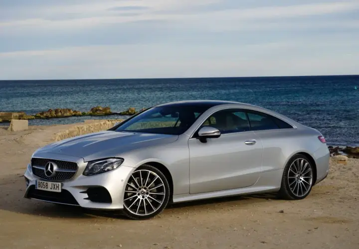 Mercedes-Benz E 220d Coupé plateado, 194 CV. Opiniones sobre su motor y diseño junto al mar.