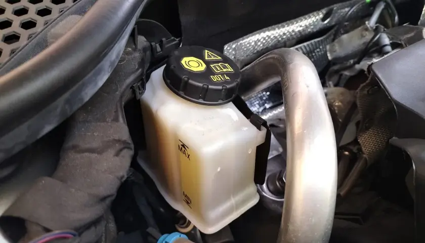 Depósito de líquido de frenos DOT 4, con marcas de nivel MAX y MIN.