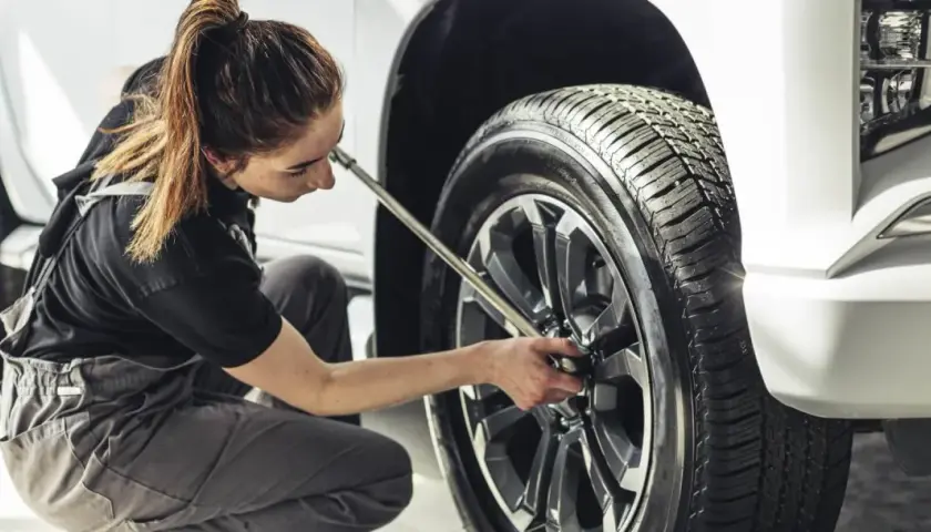 Mecánica trabajando en el cambio de ruedas de un coche.