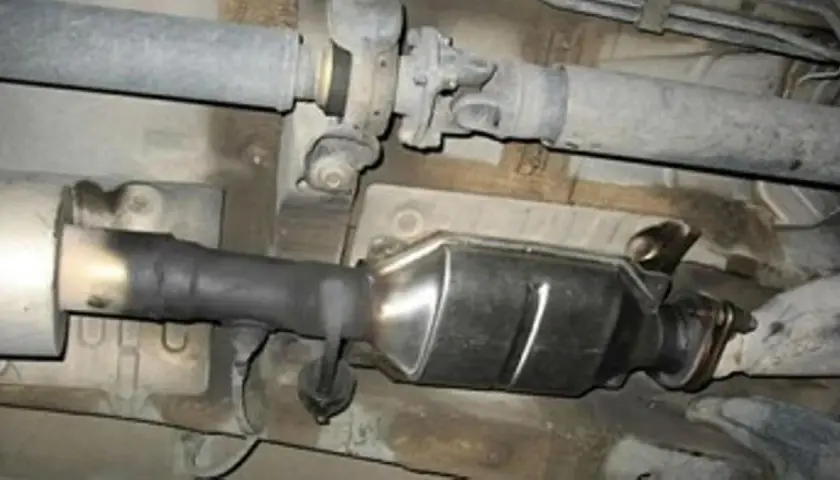 Sistema de escape de Renault con posible fallo DTC P0420. Se observa hollín en el tubo de conexión al catalizador.