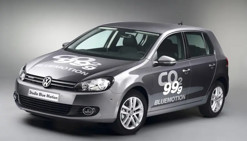 Golf gris con logo "99g CO2 BLUEMOTION" en capó y puerta, mostrando su eficiencia.
