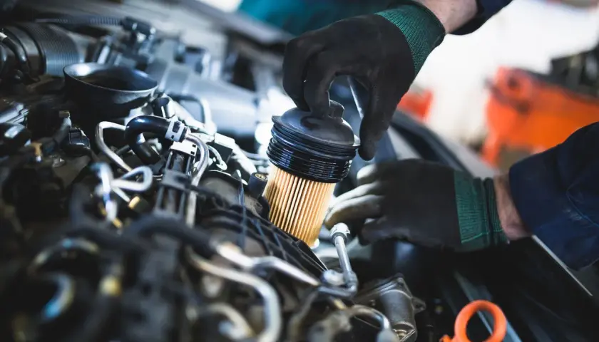 Mecánico reemplaza el filtro de combustible, una pieza esencial para el buen funcionamiento del motor.
