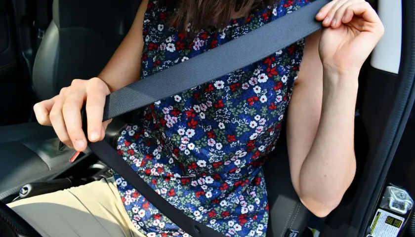 Persona se prepara para viajar, lista para cambiar cinturón de seguridad.