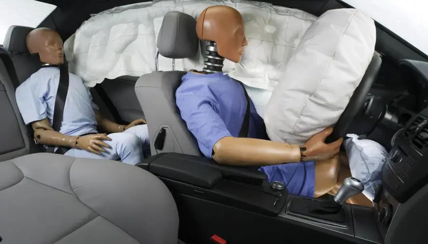 Maniquíes en un coche con airbags desplegados. Muestra cómo funciona un cinturón de seguridad en un impacto.