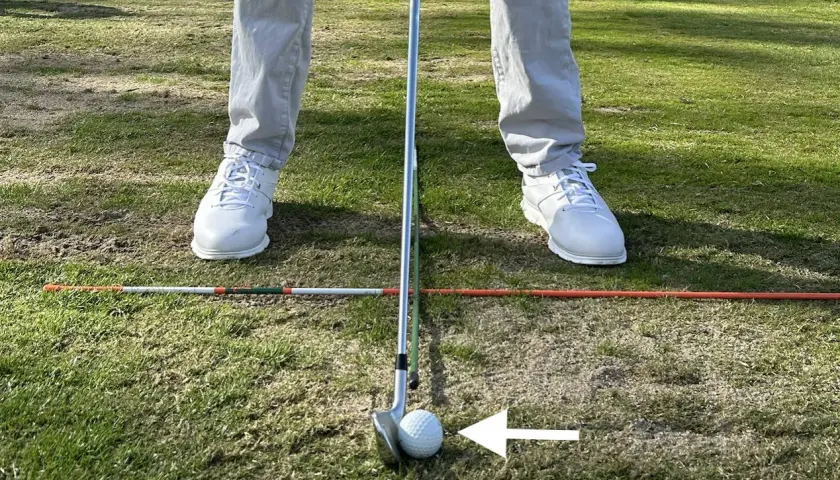 Jugador de golf en posición, con un palo y bola listos para el golpe. Los testigos averia Volkswagen Golf están en el campo, marcando la zona.