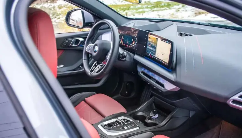Interior de BMW 118d 143cv con asientos rojos y pantalla digital. ¿Problemas con este motor?