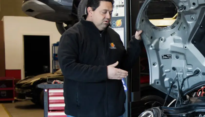 Mecánico experto en **mecánica coches eléctricos** revisa el motor de un Mini Cooper en un taller.