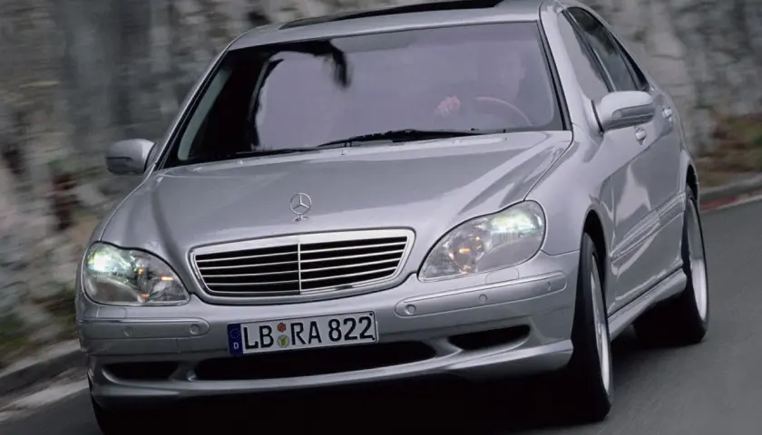 Mercedes plateado en movimiento, con el conductor visible. El sistema Airmatic parece funcionar perfectamente.