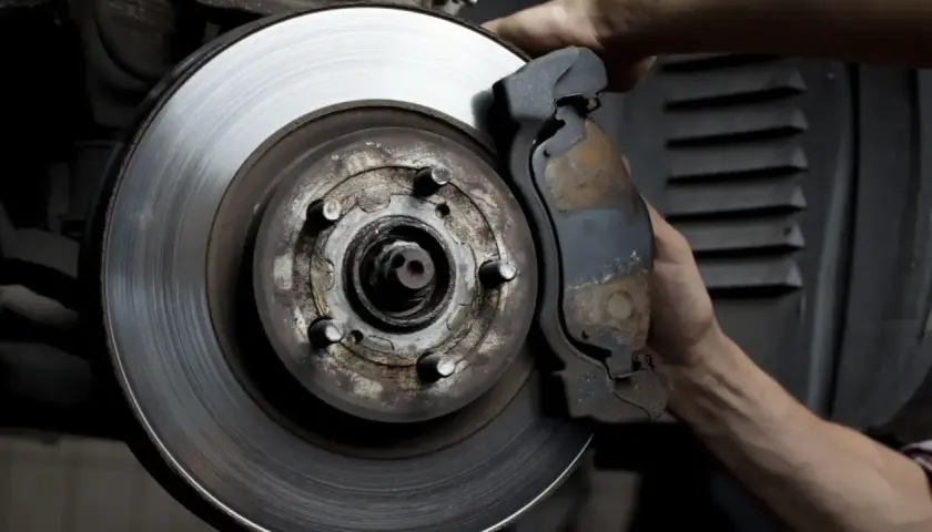 Mano ajustando la pinza de freno a un disco con rebaba.