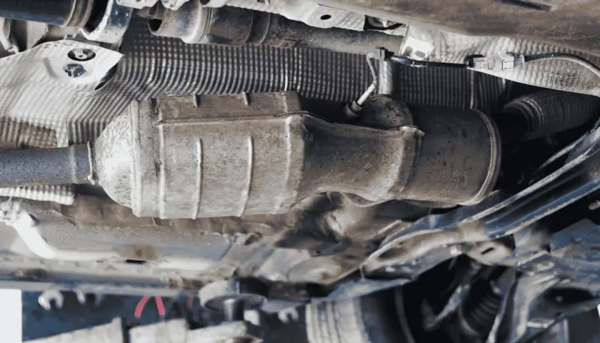 Vista inferior de un coche, mostrando el sistema de escape y el cableado. Se puede apreciar la ubicación del sensor de presión de combustible 1.6 HDI.