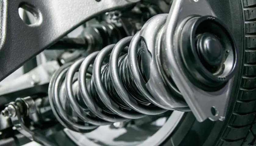 Detalle de un amortiguador y muelle de coche. ¿Cuánto cuesta cambiar los amortiguadores del coche?