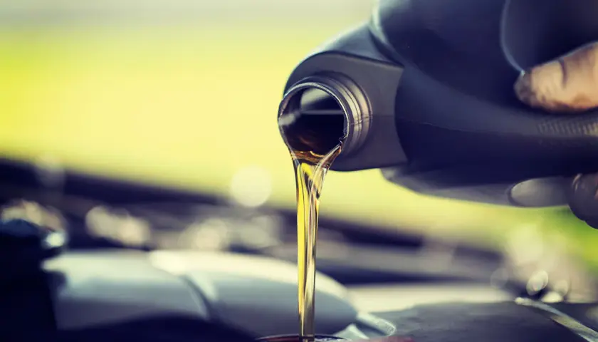 Vertiendo aceite de coche nuevo, ya que el aceite de coche caduca y necesita ser reemplazado para el buen funcionamiento del motor.