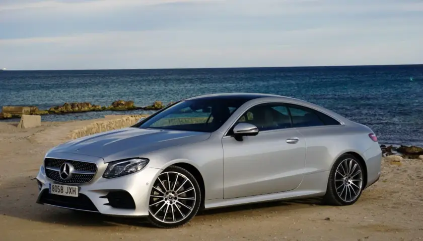Mercedes-Benz E 220d Coupé plateado, 194 CV. Opiniones sobre su motor y diseño junto al mar.