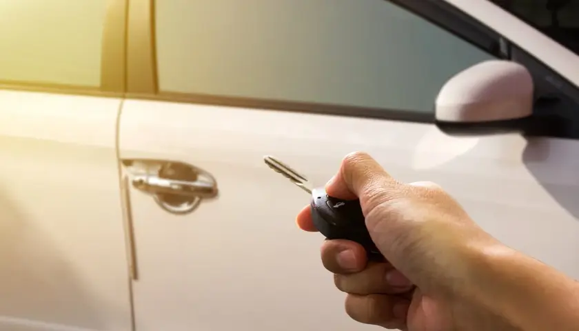 Mano sujetando llave para resetear cierre centralizado del coche.