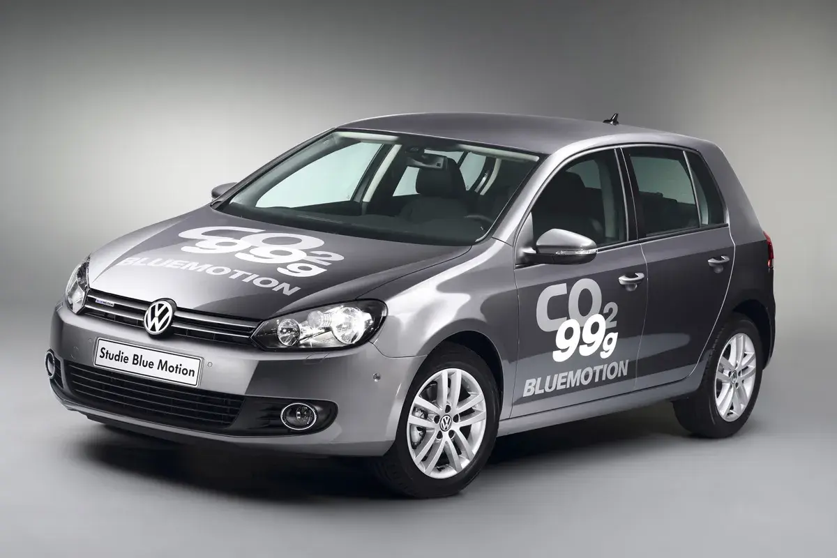Golf gris con logo "99g CO2 BLUEMOTION" en capó y puerta, mostrando su eficiencia.