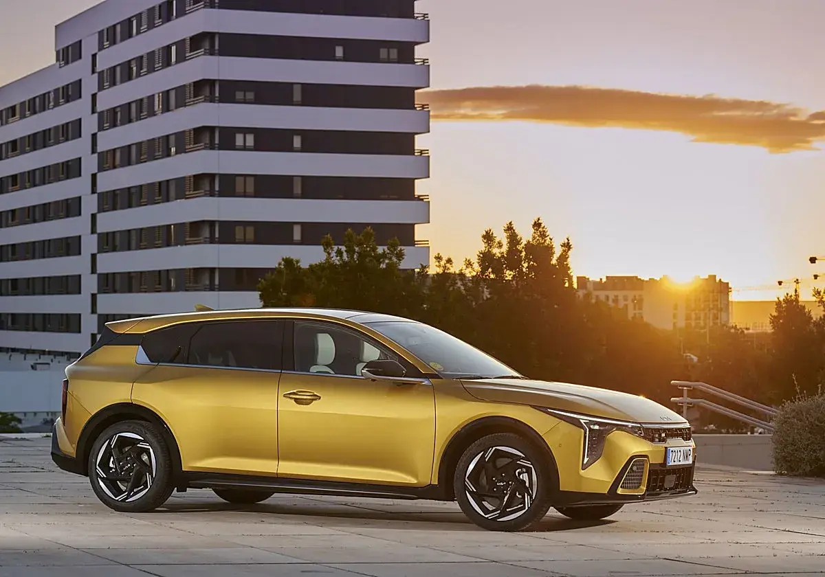 Coche dorado moderno aparcado frente a un edificio al atardecer. ¿Buscas cómo bajar el CO2 de un coche de gasolina?