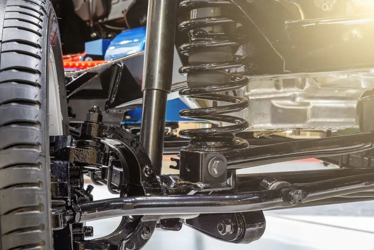 Detalle de la suspensión de un coche, con amortiguador y muelle helicoidal. Ideal para quienes buscan cambiar suspension coche.