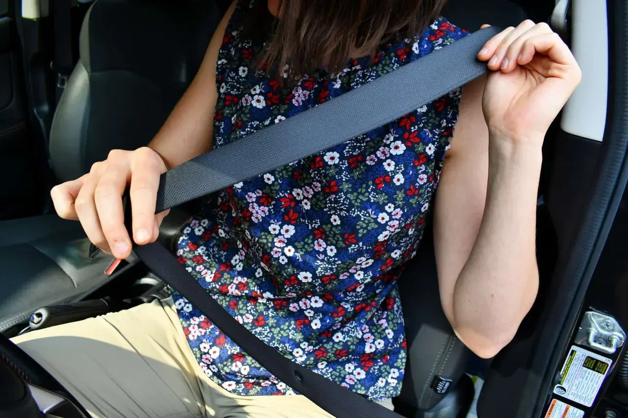 Persona se prepara para viajar, lista para cambiar cinturón de seguridad.