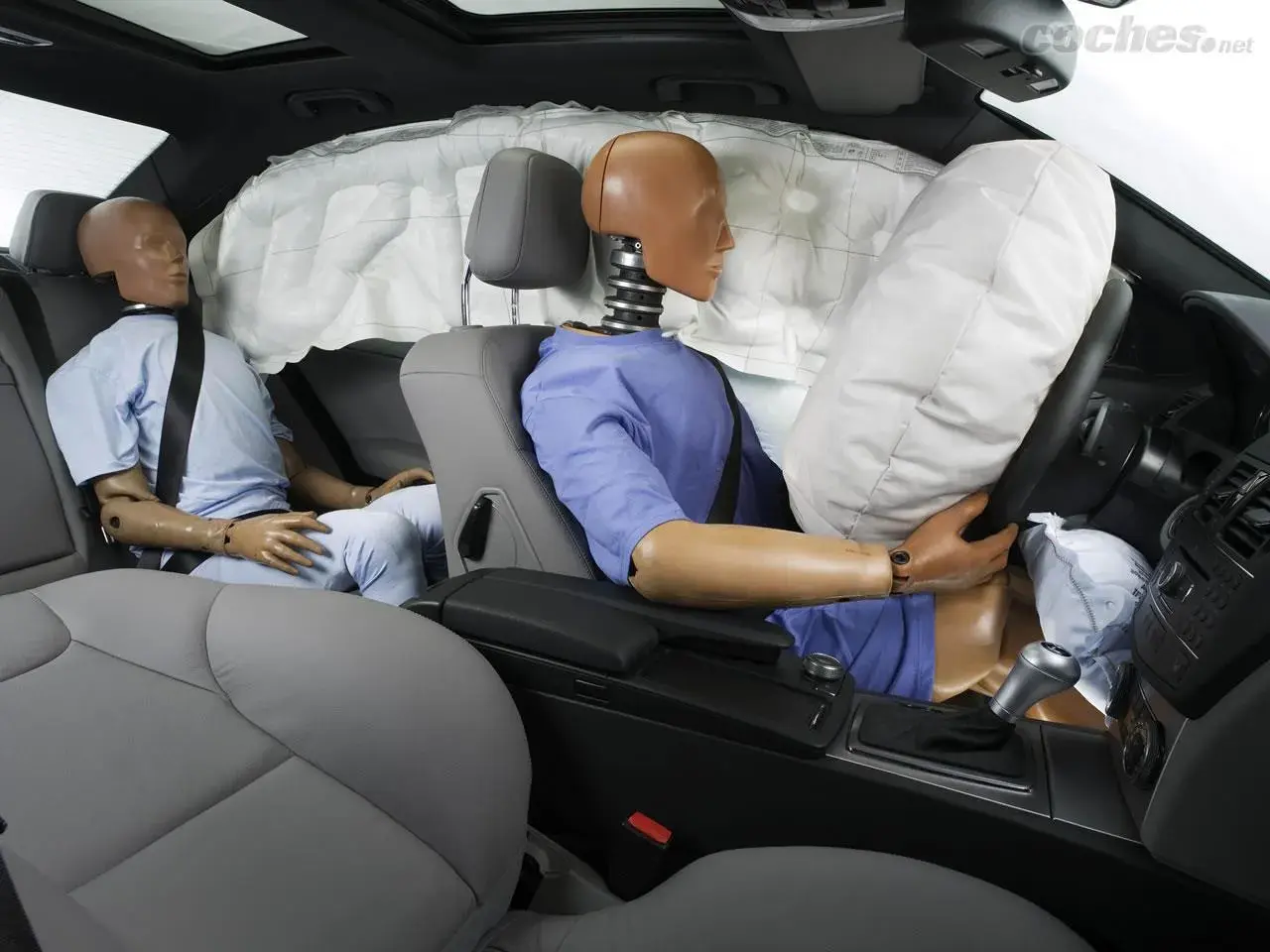 Maniquíes en un coche con airbags desplegados. Muestra cómo funciona un cinturón de seguridad en un impacto.