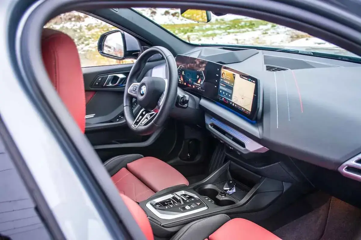 Interior de BMW 118d 143cv con asientos rojos y pantalla digital. ¿Problemas con este motor?